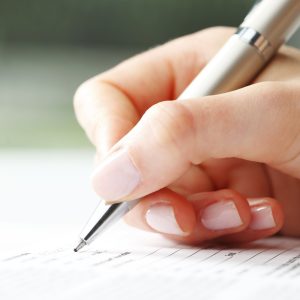 Businesswoman writing on a form